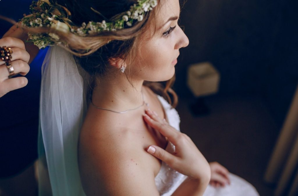 Préparatifs d'une mariée coiffée d'un voile et d'une couronne de fleurs pour illustrer la signification coutume mariage quelque chose de bleu